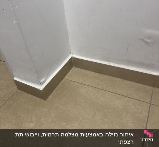 רצפה פינתית עם קיר לבן ואריחים חומים